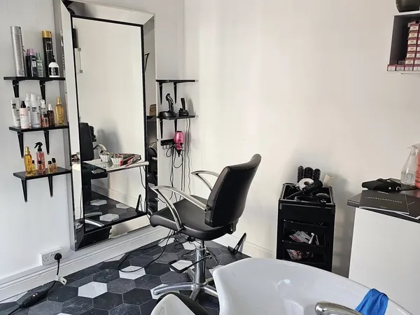 The studio: a styling chair, large mirror, product shelves and a wash basin