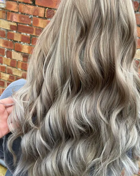 Long ash blonde hair with silvery tones, styled in loose waves